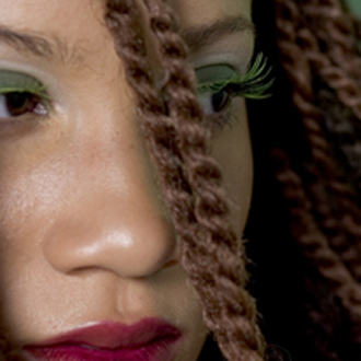 Directed beauty portrait with bold color styling and braided hair.